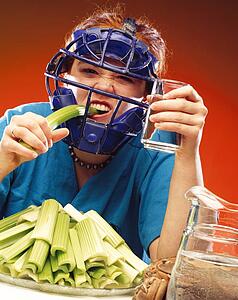 Woman in sports equipment eating celery