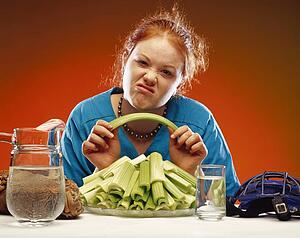 Women with plate of celery and sports equipment