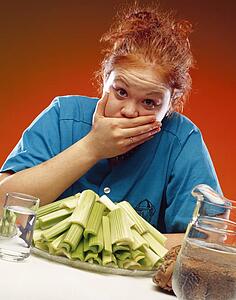 Woman with plate of celery and sports equipment