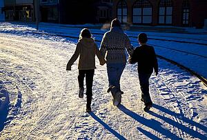 Three people walking on the snow