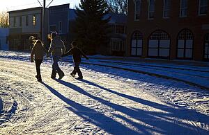 Three people walking on the snow