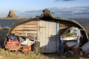 Barn beside volcanic mound called Beblowe Craig, England