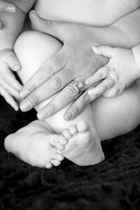 Mom's hands with baby's feet and hands