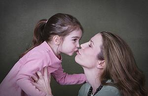 Mother and daughter kissing
