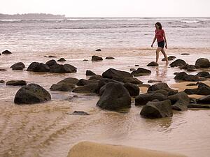Woman walking along the beach, Kauai, Hawaii, USA