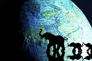 Elephant silhouettes in front of a globe