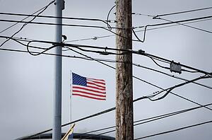 American flag behind phone wires and electrical wires