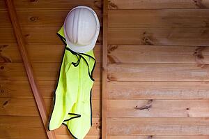 Reflective vest and hardhat hanging on wall