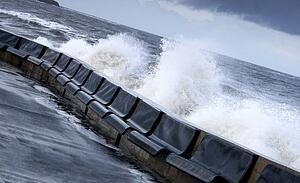 Waves crashing into concrete wall