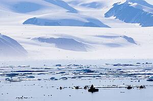 Kayakers by ice berg off coast of Nunavut, Canada