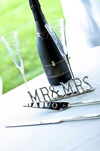 Chrome 'Mr & Mrs' sign next to champagne and cake server