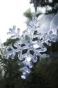 Snowflake holiday ornament on tree