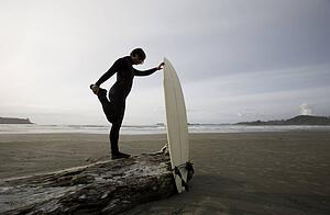 Surfer stretching on beach