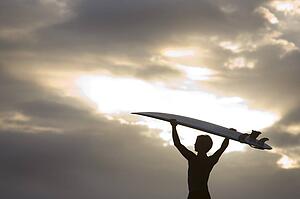 A surfer on Muriwai Beach, New Zealand