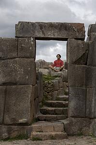 A young man meditates in ancient Incan ruins outside Cuzco, Peru