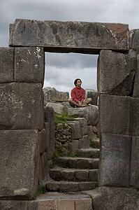 A young man meditates in ancient Incan ruins outside Cuzco, Peru