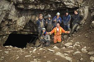 Climbers cheering outside cave, Cadomin, Alberta, Canada