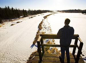 Man looking at landscape from footbridge, rear view
