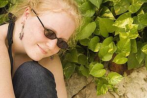 Teenage girl in sunglasses by green plant