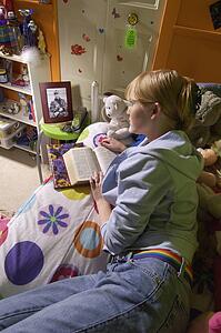 Girl reading Bible in bedroom