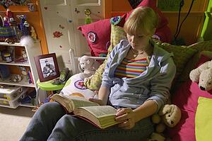 Girl reading Bible in bedroom