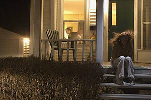 Woman sitting outside of her house