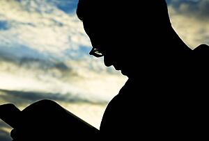 Silhouette of man reading