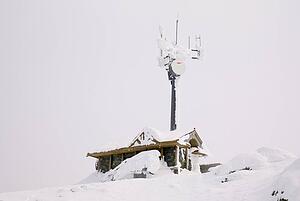 Snow covered building and satellite tower