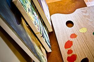 An artist's palette and canvases