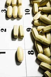 Vitamins Divided On A Calendar Page