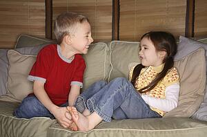Boy and girl playing on a couch