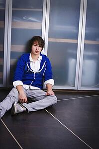 Portrait Of A Teenage Boy Sitting On The Ground