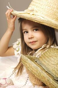 Girl and teddy bear wearing straw hats
