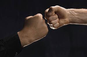 Two men knocking fists together