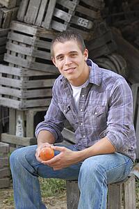 Young man sitting holding an apple
