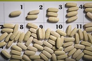 Pills scattered on a calendar page