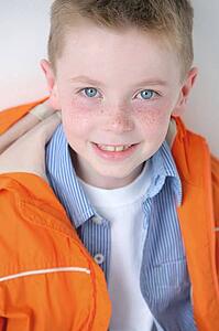 Young boy with freckles smiling at camera