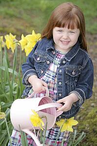 Little girl watering flowers