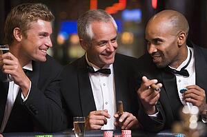 Three men in casino playing roulette and smiling (selective focus)