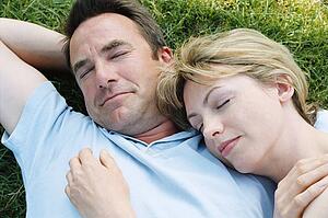 Couple lying outdoors sleeping