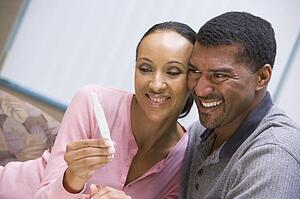 Couple with pregnancy test smiling