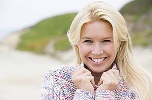 Woman standing at beach smiling