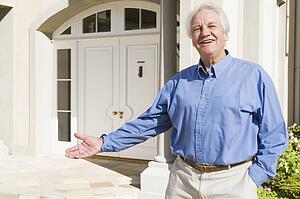 Senior man standing outside his home