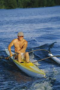 Kayaker rowing in calm waters (selective focus)