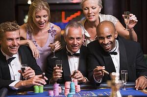 Five people in casino playing roulette and smiling (selective focus)