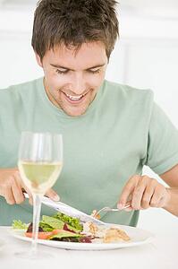 Young Man Enjoying meal, mealtime With A Glass Of Wine