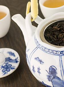 Green Tea leaves In a Tea pot with Cups