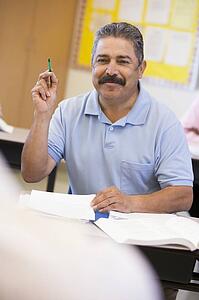 Adult student in class volunteering for teacher (selective focus)