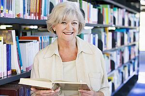 Woman in library holding book (depth of field)