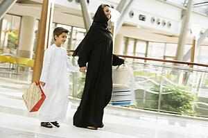 Woman and young boy walking in mall smiling (selective focus)